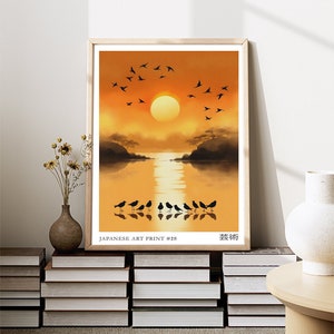 Puede incluir: Una impresi&oacute;n de arte japonesa que presenta una puesta de sol sobre un cuerpo de agua tranquilo con una bandada de p&aacute;jaros volando por encima. La impresi&oacute;n est&aacute; enmarcada en un marco de madera claro y tiene el texto "JAPANESE ART PRINT #26" y "芸術" en la parte inferior.