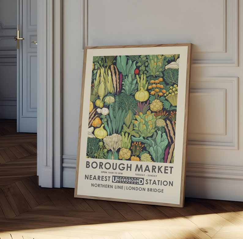 Puede incluir: Una impresi&oacute;n art&iacute;stica enmarcada con una colorida ilustraci&oacute;n de varias verduras y plantas. La obra de arte incluye el texto "BOROUGH MARKET" y "NEAREST UNDERGROUND STATION". La impresi&oacute;n se exhibe en una habitaci&oacute;n con piso de madera y puertas blancas.