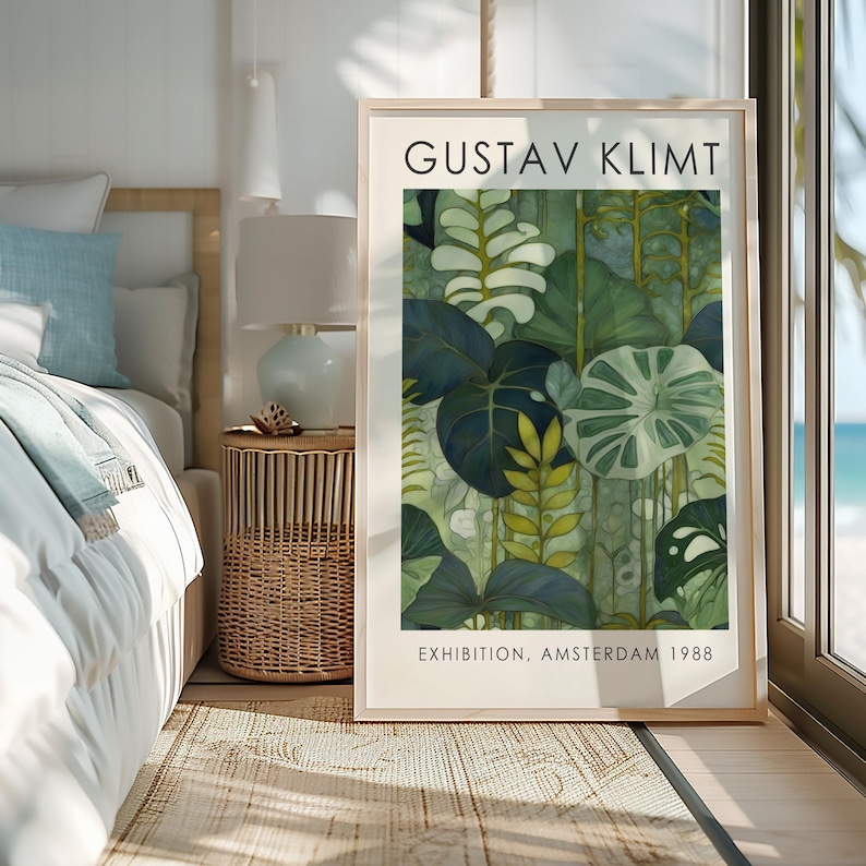 May include: A framed art print featuring a botanical illustration in shades of green, with the text "GUSTAV KLIMT" at the top and "EXHIBITION, AMSTERDAM 1988" at the bottom. The artwork is displayed in a bright room with a bed and a side table.