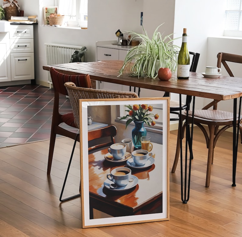May include: A framed print of a still life painting featuring a table setting with four cups of coffee, a vase of flowers, and a glass of juice. The painting is set against a window with sunlight streaming in.