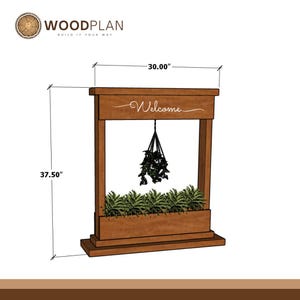 May include: A wooden planter with a rectangular design, measuring 30 inches wide and 37.5 inches tall. The word "Welcome" is scripted across the top. The planter includes a hanging plant and a row of green plants at the base.