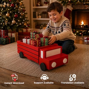 May include: A red wooden toy truck with black wheels and a white front panel, carrying several small gift boxes wrapped in red and green patterned paper with gold ribbons, positioned on a textured rug in a room with holiday decorations.