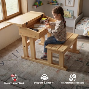 May include: A light-coloured wooden school desk with a hinged top and an attached bench seat. The desk features a storage compartment underneath the lid, which is currently open, revealing a stack of books and a drawing on the writing surface.