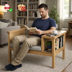 May include: A light oak armchair with an attached side table. The chair has a gray cushion and a built-in shelf holding books and a small potted plant. A cup and saucer sit on the table. The person is reading a book.