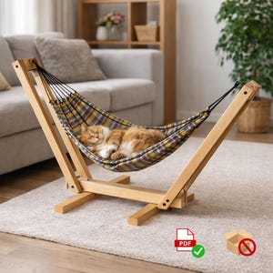 Könnte beinhalten: Eine Katzenhängematte aus Holz mit einem Bett aus kariertem Stoff. Eine orange-weiß getigerte Katze schläft in der Hängematte. Die Hängematte wird von einem Holzrahmen getragen. Der Hintergrund umfasst eine Couch, Regale und eine Pflanze.