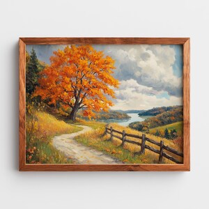 May include: A framed landscape painting of an autumnal scene. A dirt track winds through a grassy hillside towards a wooden fence and a river. A large tree with orange leaves dominates the left, under a cloudy sky.
