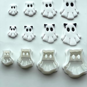 May include: A set of 10 white plastic cookie cutters in the shape of ghosts. The cutters are in various sizes and have different facial features, including eyes, mouths, and noses.