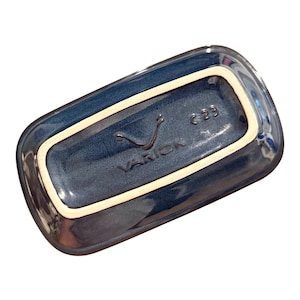 May include: A rectangular ceramic dish with rounded corners, featuring a deep blue glazed finish and a contrasting cream-colored rim. The underside is embossed with the text VARICK and the alphanumeric code C23 in the center of the base.