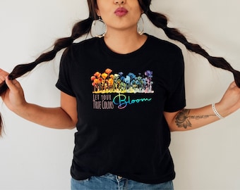 May include: Black t-shirt with a rainbow watercolor floral design and the text "Let your true colors bloom".