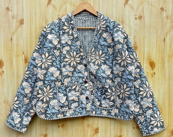 May include: A gray quilted jacket with a floral print and a button closure. The jacket has two pockets and a striped lining.