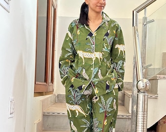 May include: A green pajama set with a jungle print featuring toucans, leopards, and palm trees. The set includes a long-sleeved shirt and matching pants.