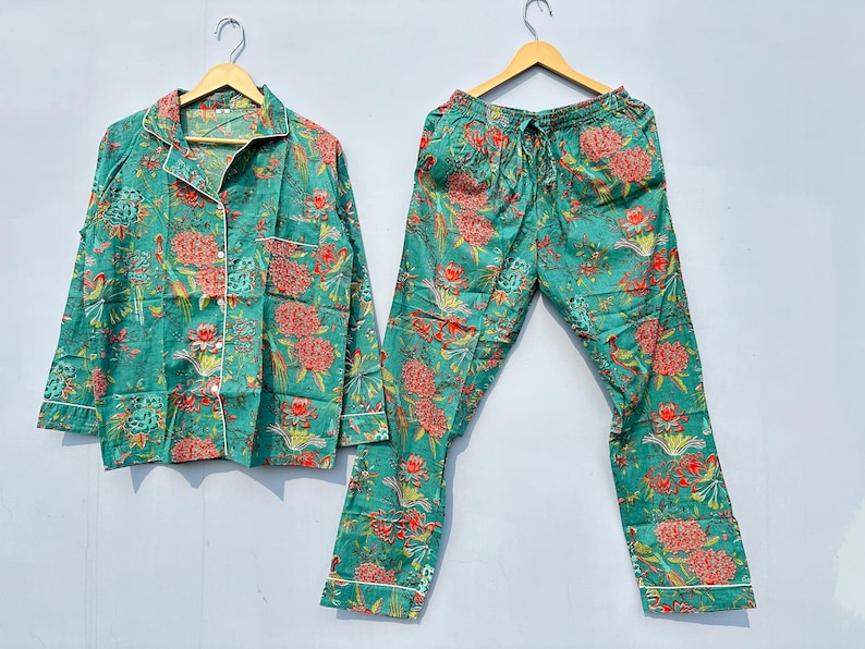 May include: A teal blue pajama set with a floral print. The top has a button-up front and long sleeves. The pants have an elastic waistband and a drawstring.