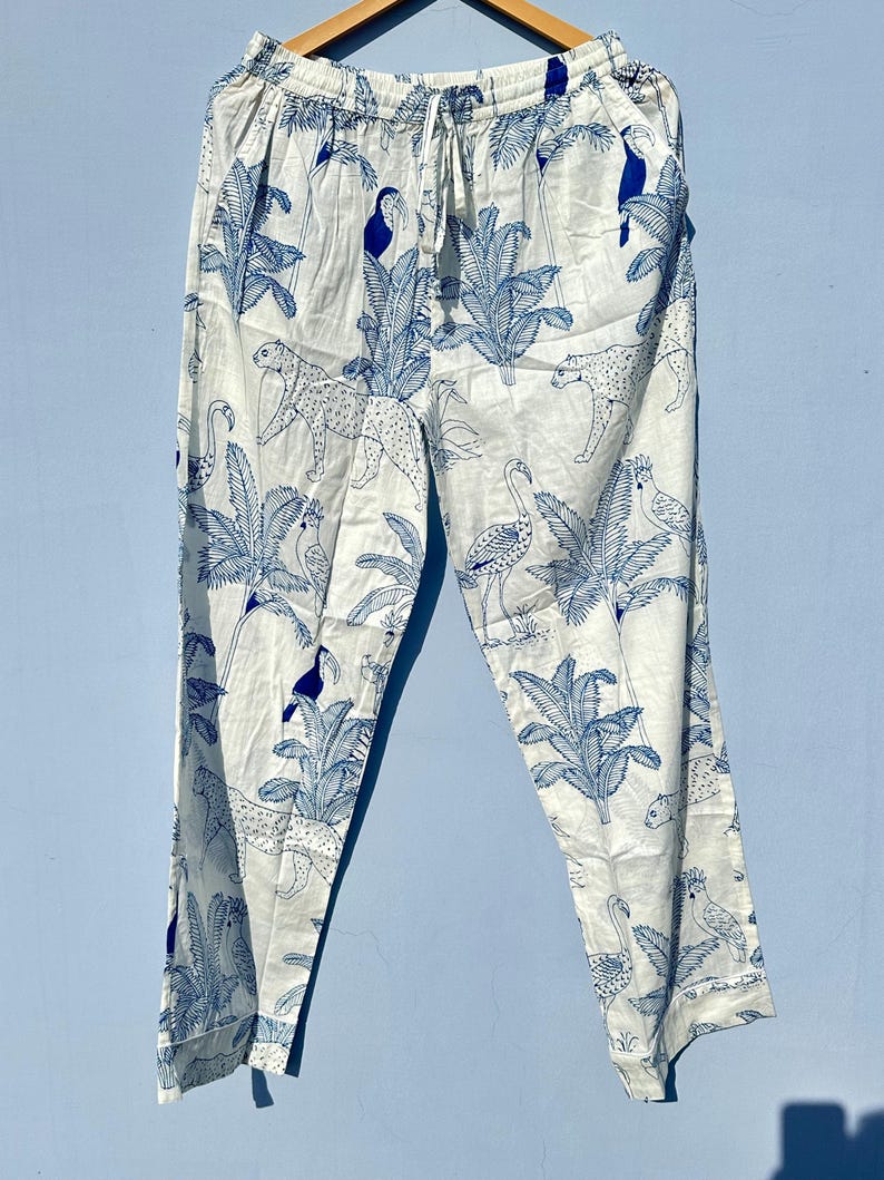 May include: White trousers with a blue and white tropical print featuring toucans, flamingos, and leopards.