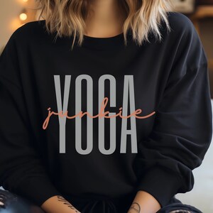 May include: Black sweatshirt with the text "yoga junkie" in grey and pink lettering.