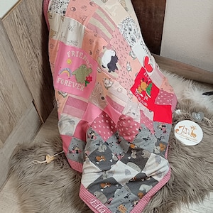 Könnte beinhalten: Eine rosa und graue Patchwork-Babydecke mit verschiedenen Tierdrucken und besticktem Text, darunter "Friends Forever" und "Ella 2020".
