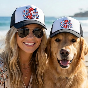 May include: Two trucker hats with black brims and white front panels featuring the text USA in a red, white, and blue patterned design. The hats have black mesh backs and adjustable snapback closures, displaying a patriotic graphic print on the front.
