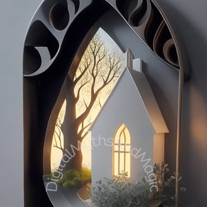 May include: A white paper house with a lit window sits in a metal frame with a cutout tree and a sunset behind it. The house is surrounded by greenery and a small bowl.