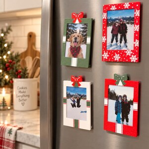 May include: Four rectangular magnetic picture frames attached to a stainless steel surface. Two frames are red with white snowflake patterns, one is green with a white ribbon design, and one is white with green and red ribbon accents.