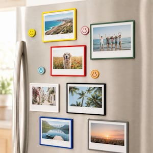 May include: A collection of seven rectangular magnetic photo frames in yellow, red, green, white, black, blue, and gray, each holding a different photograph. Four small circular smiley face magnets in yellow, pink, blue, and orange are included.