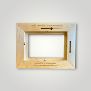 May include: The back of a wooden picture frame with a slot for hanging and a space for an inscription. The inscription reads "Framing Life's Journey - www.journeyframes.com Your first line of inscription here Your second line of inscription here"