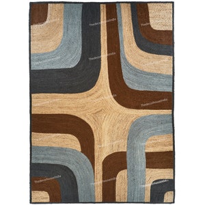 May include: A rectangular jute rug with a geometric design. The rug features curved lines in shades of brown, grey, and beige, creating a retro-inspired pattern. The rug has a dark border and is suitable for living rooms or bedrooms.