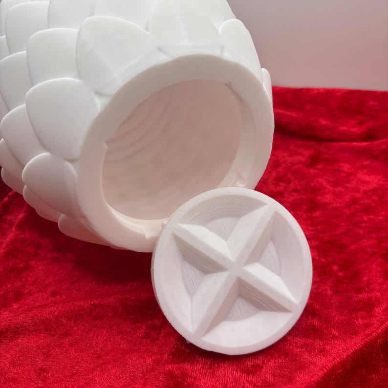 May include: White ceramic pineapple shaped container with a removable lid. The lid has a star-shaped design.