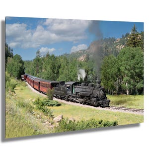May include: A black steam locomotive pulls a train of red passenger carriages through a lush green forest. The train is moving along a track that winds through the trees. There is smoke coming from the locomotive's chimney.