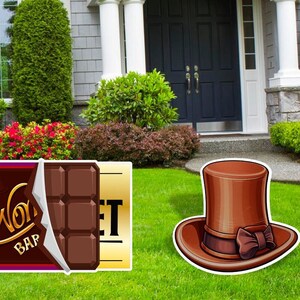 Może przedstawiać: Brązowy batonik czekoladowy z nadrukiem "Wonka Bar" na opakowaniu i złoty bilet z nadrukiem "Golden". Brązowy cylinder z brązową kokardką leży na zielonej trawie.