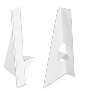 May include: Two white cardboard easel stands, one in profile and one facing forward. Each stand has a triangular shape with a support piece. The stands are designed to hold signs or displays.