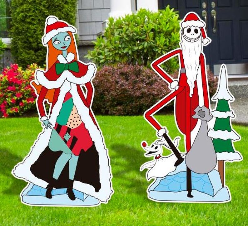 Może przedstawiać: Zestaw świątecznych dekoracji ogrodowych z Jackiem Skellingtonem i Sally z filmu Koszmar przed świętami. Jack jest przebrany za Świętego Mikołaja, a Sally nosi czerwoną i zieloną sukienkę z białym futerkiem. Zestaw zawiera małą białą figurkę psa.