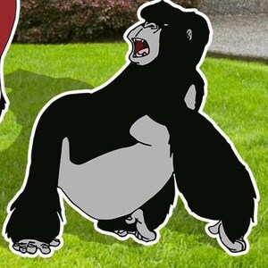 May include: A black and grey cartoon gorilla with an open mouth, roaring, standing on a green grassy surface.