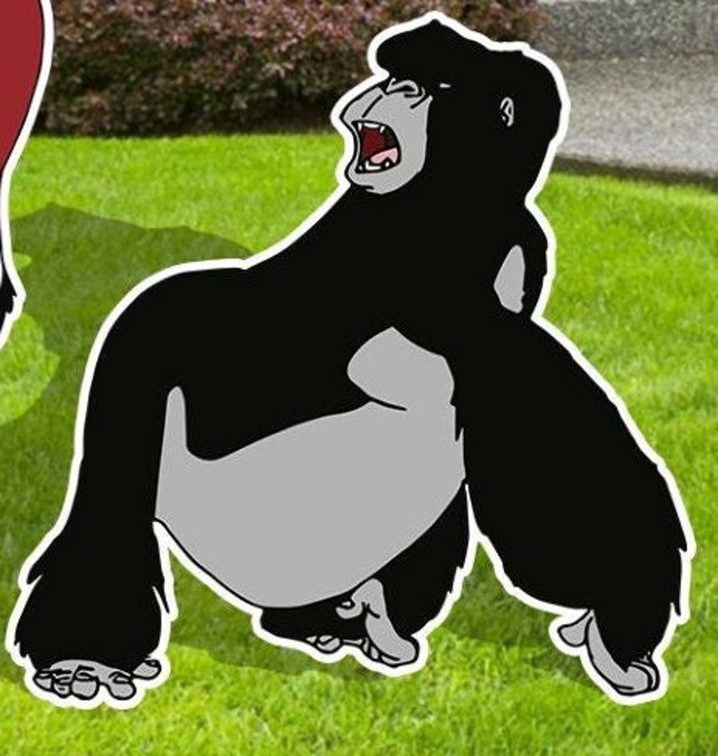 May include: A black and grey cartoon gorilla with an open mouth, roaring, standing on a green grassy surface.