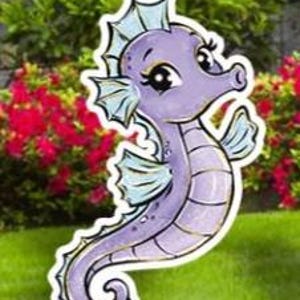 May include: A whimsical, purple seahorse yard stake with a cartoonish design. The seahorse has light blue fins and a white outline, set against a backdrop of green grass and red flowers.