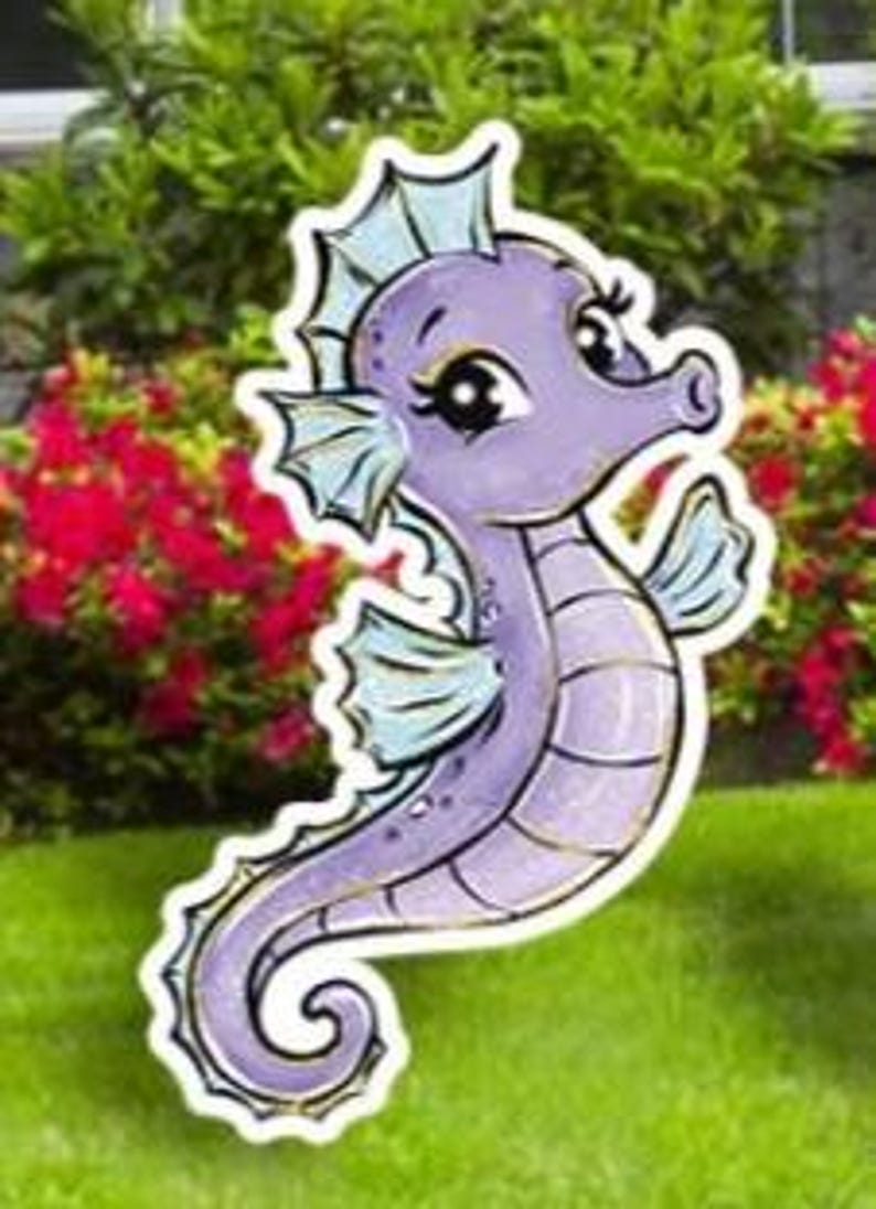 May include: A whimsical, purple seahorse yard stake with a cartoonish design. The seahorse has light blue fins and a white outline, set against a backdrop of green grass and red flowers.