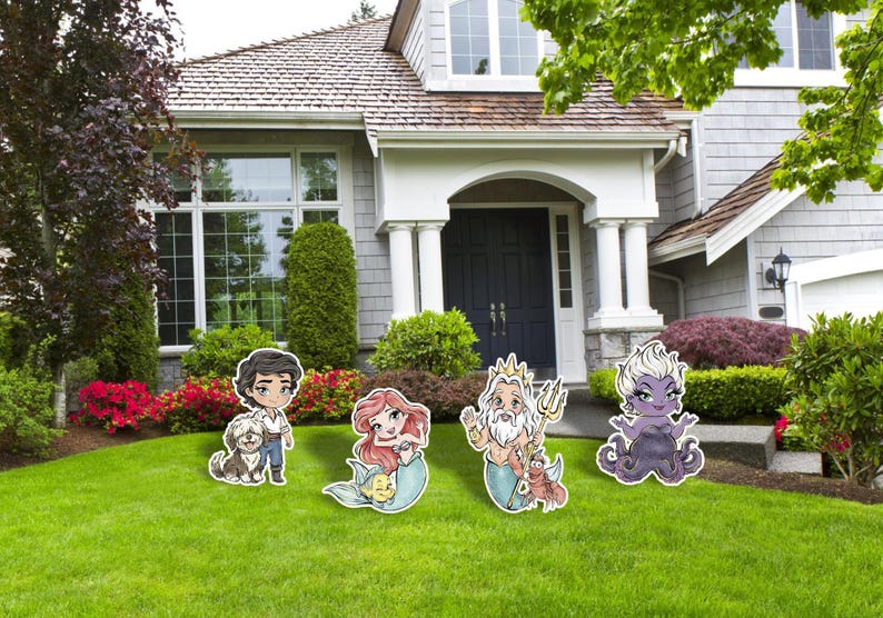 May include: Cartoon character yard decorations featuring Ariel, Prince Eric, King Triton, and Ursula, with a dog. The characters are standing on a green lawn in front of a house with a white porch and a dark blue door.