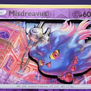 May include: A 3D shadow box trading card featuring the purple ghost-type Pokémon Misdreavus. The card displays the name Misdreavus, 60 HP, and the text NO. 200 Screech Pokémon HT: 2'4" WT: 2.2 lbs. The layered design shows a red building background.