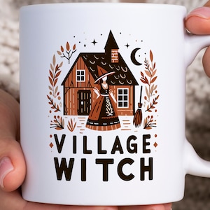 May include: White ceramic mug with a brown and white illustration of a witch standing in front of a house with a crescent moon and stars in the background. The text "VILLAGE WITCH" is printed in black below the illustration.