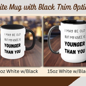 Puede incluir: Dos tazas blancas con borde y asas negras. Las tazas tienen el texto "I may be old but my knee is younger than you" impreso en negro. La taza de la izquierda es una taza de 11 oz y la taza de la derecha es una taza de 15 oz.