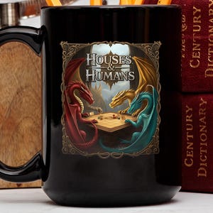 May include: Black ceramic mug with a graphic of three dragons playing a board game. The dragons are red, gold, and blue. The text "Houses & Humans" is printed on the mug.