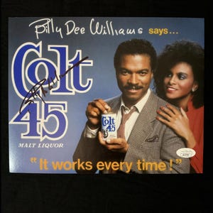 May include: A vintage advertisement for Colt 45 Malt Liquor featuring actor Billy Dee Williams. The ad features the text "Billy Dee Williams says... Colt 45 Malt Liquor "It works every time!"