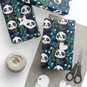 Papel de regalo con diseño de oso panda en blanco y negro con hojas florales sobre fondo azul oscuro, de Agnes Pembroke.