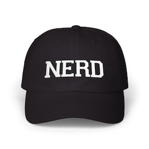Peut inclure: Casquette de baseball noire avec le mot "NERD" blanc sur le devant. La casquette a une visière incurvée et une conception classique à six panneaux. Le texte est en gras.