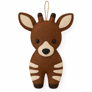 May include: A felt okapi ornament featuring a dark brown body with cream-colored stripes on the legs and face. The animal has large ears, two small dark brown ossicones on top of its head, black bead eyes, and a tan hanging loop at the top.