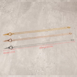 Puede incluir: Tres delicados collares con un colgante en forma de coraz&oacute;n en forma de tijeras. Los collares son de oro, oro rosa y plata. Los collares miden 260 mm de largo y el colgante mide 40 mm de largo.