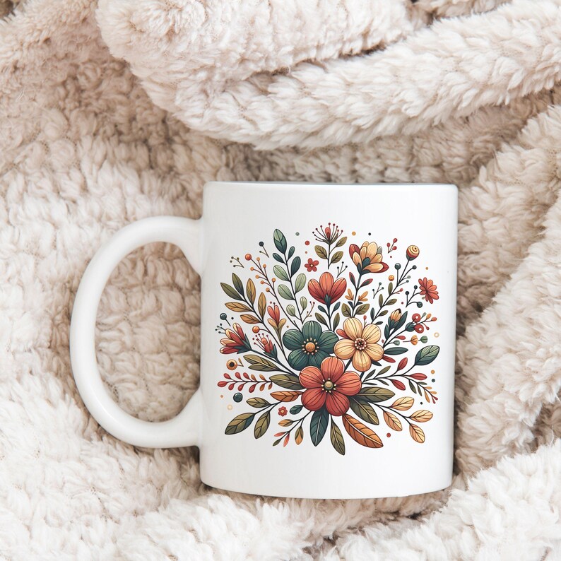 Peut inclure: Une tasse en c&eacute;ramique blanche avec un motif floral. Le motif repr&eacute;sente un bouquet de fleurs dans des tons de rouge, orange, jaune et vert.