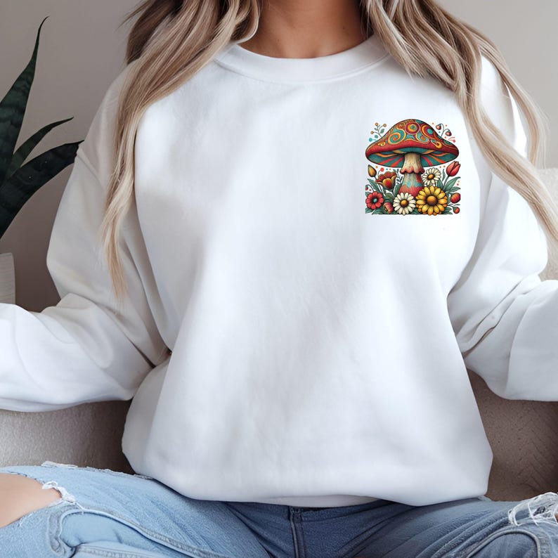 May include: White sweatshirt with a colorful mushroom and flower graphic on the front.