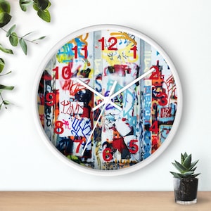 May include: White round clock with black hands and red numbers on a graffiti-style background. The numbers 12, 1, 2, 3, 4, 5, 6, 7, 8, 9, 10, and 11 are visible.