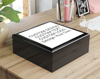 May include: A black wooden box with a white top featuring the text "CUSTOM DESIGN CUSTOM TEXT CUSTOM LOGO Design Your Own". The box is rectangular and sits on a wooden surface.