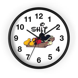 May include: A black and white clock with a Mickey Mouse character lying on a mousetrap. The clock face has black numbers and the word "SHIT" written in a circle above the character.