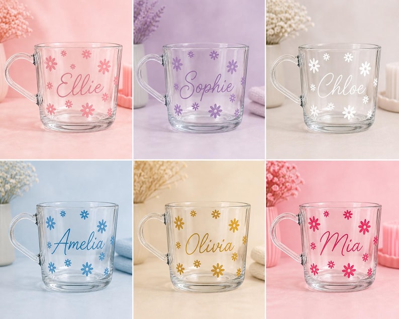 May include: A collection of six clear glass mugs, each featuring a unique name in cursive script surrounded by small flower decals. The names include Ellie in pink, Sophie in purple, Chloe in white, Amelia in blue, Olivia in gold, and Mia in magenta.